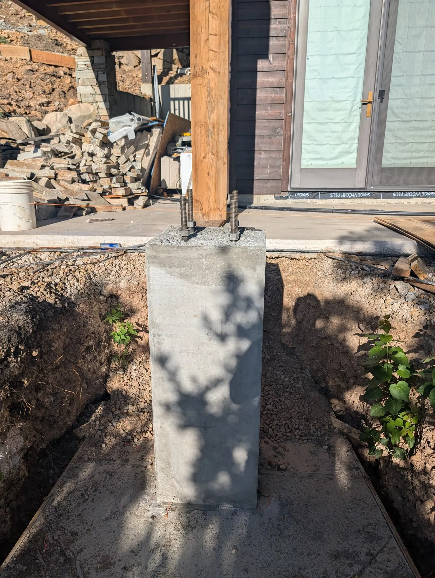 Pier and anchor bolts under a timber post — A cast concrete pier with anchor bolts set for the post above